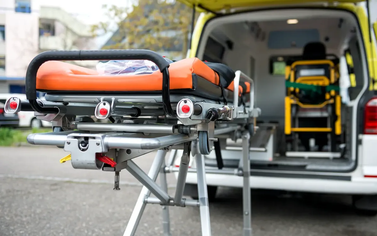 Mobimed-Mitarbeiter mit Patientenliege am offenen Heck eines Fahrzeugs